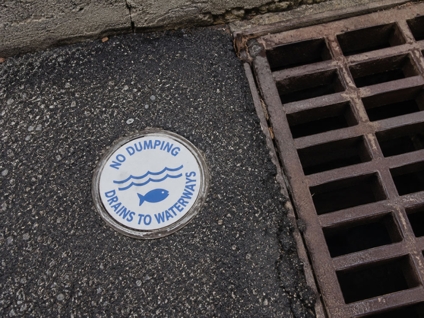 Drains to waterways storm drain marker in roadway
