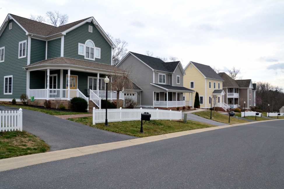 Housing development with paved driveways, paved road, and concrete sidewalks.