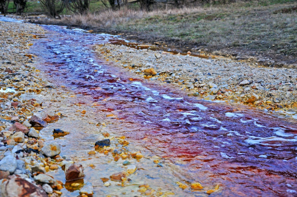 Discolored runoff stream of contaminated water from a copper mine.