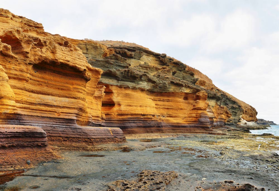 An eroded and scoured sandstone river bank.