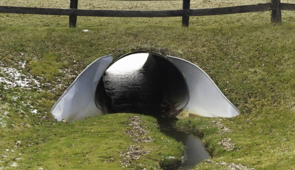 The flared galvanized headwall of a culvert.