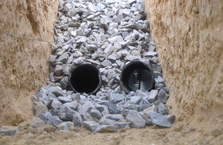Two perforated HDPE pipes buried in gravel underdrain.