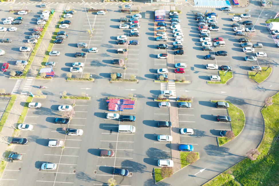 A large shopping center parking lot on a hot, sunny day.