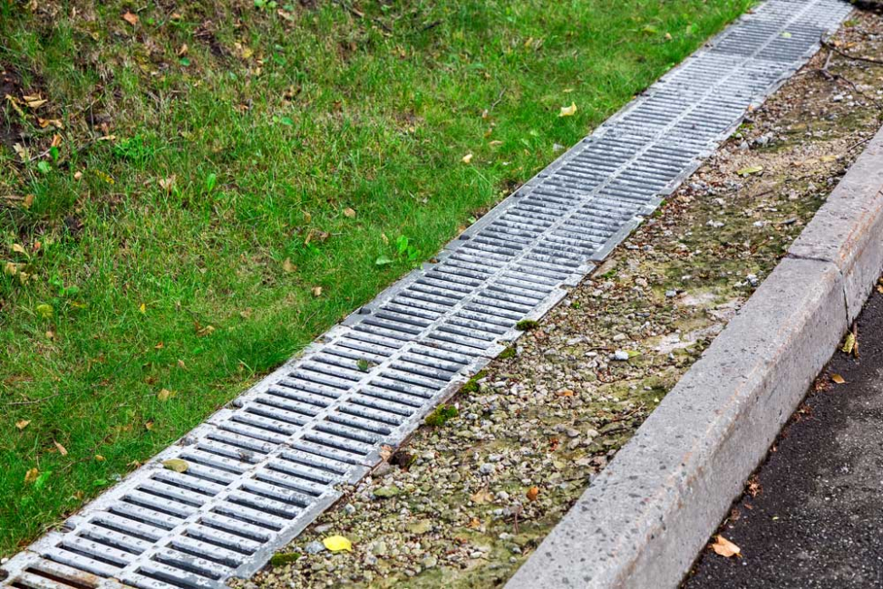 Long trench drain next to the road.