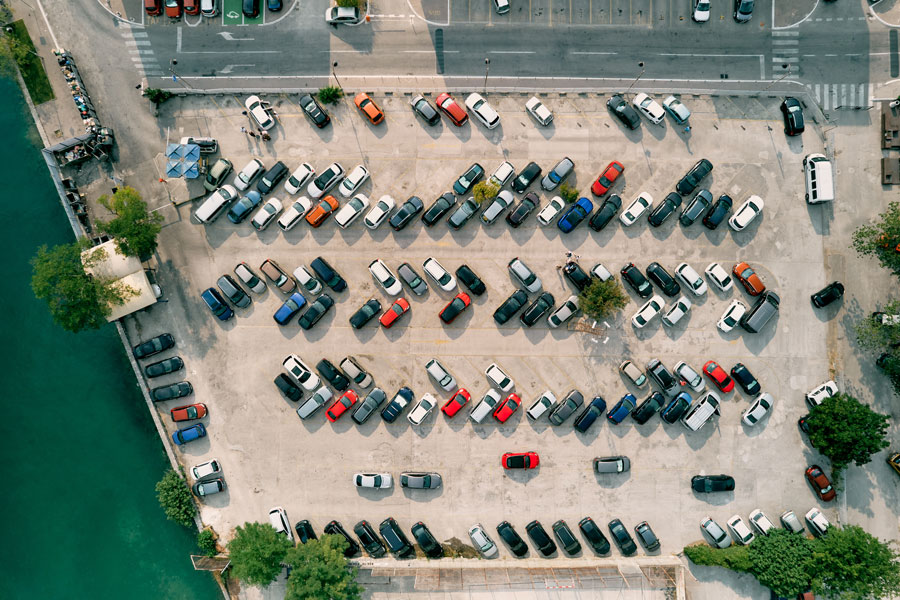A large paved parking lot next to a pond